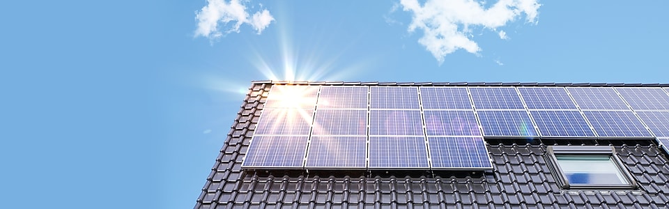 solarzellen-auf-dem-dach-eines-einfamilienhauses-unter-blauem-Himmel