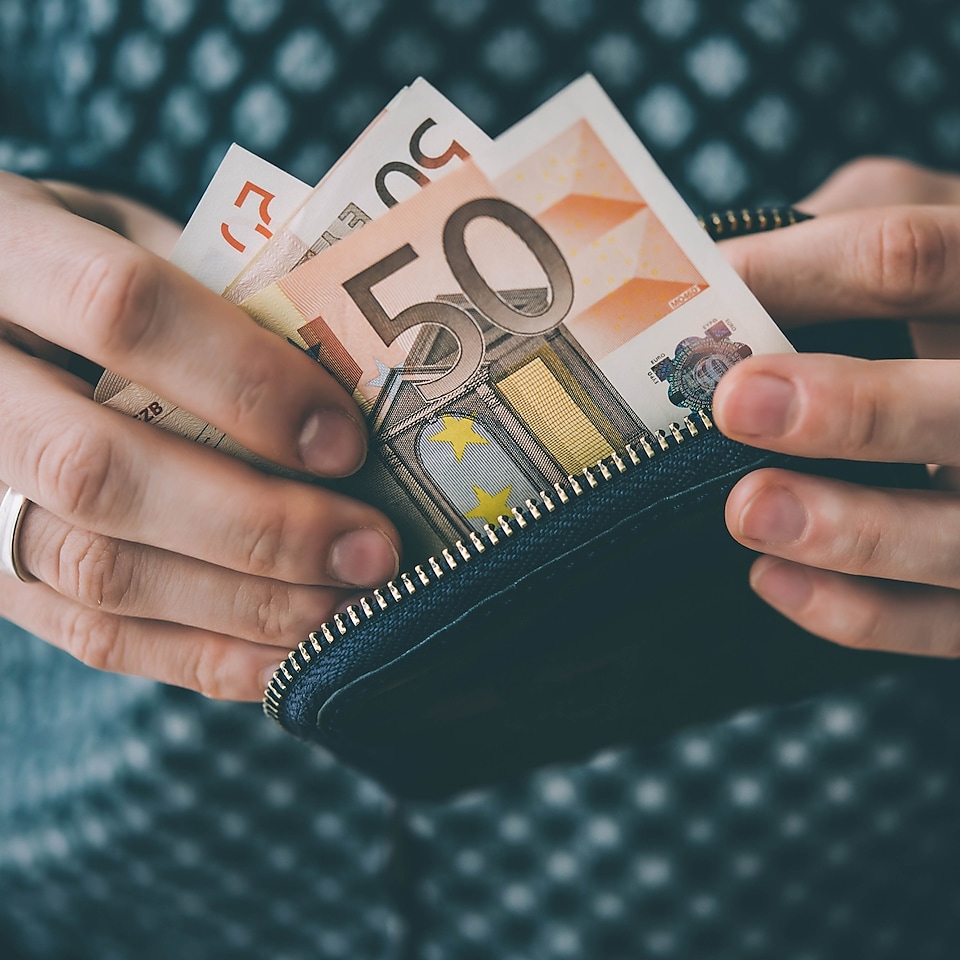 50-Euro-Scheine werden aus einer Geldbörse entnommen